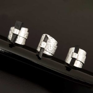 drei weisse Ringe mit laengliche schwarze Steinen